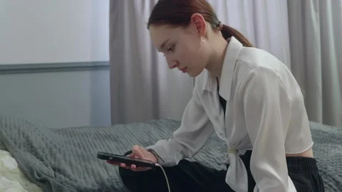 Young woman dancing while using smartphone on bed Stock Footage 310533740