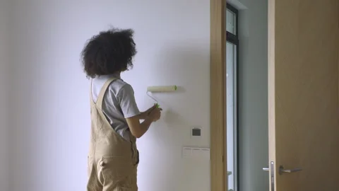 A young woman is decorating the walls during the renovation of her apartment. Stock Footage 313679751