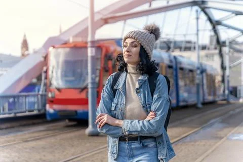 A young woman in a denim jacket is talking on the phone and waiting for a t.. Stock Photos