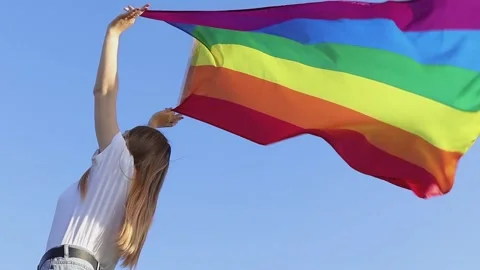 A young woman develops a rainbow flag, LGBT community 스톡 동영상 140150544
