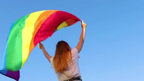 A young woman develops a rainbow flag LGBT community Video stock 140150607