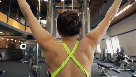 Young woman do exercise using training machine in gym. View from back Video stock 74106343
