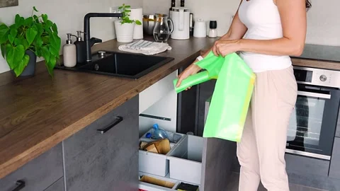Young woman do replacing garbage bag in kitchen trash can. Plastic, paper, bio Stock Footage 276570199
