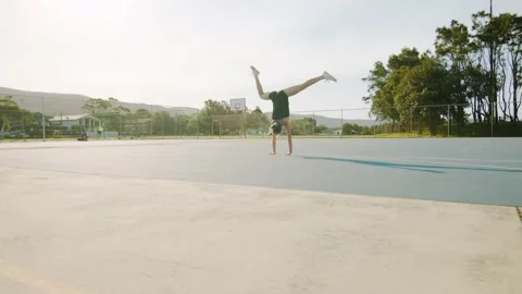 Young Woman Does Dynamic Straddle Handstand on Sunny Morning. Wide Shot Stock Footage 130989893