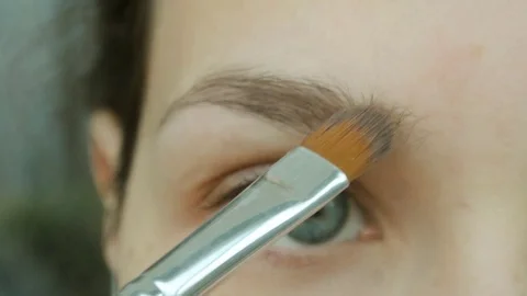 Young woman does her eyebrows shadows. Eye natural makeup at home. Stock Footage 82336186