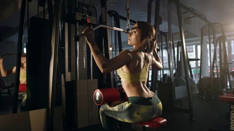 Young woman doing exercise for back on training machine Stock Footage 71814497