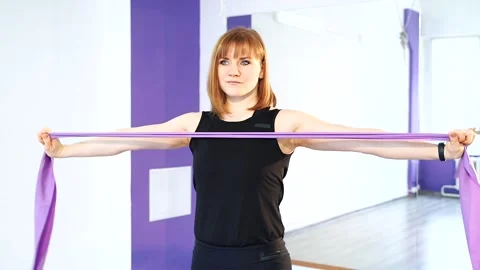 Young woman doing exercises for developing muscles of hands, back and abdominal. Stock Footage 104709299