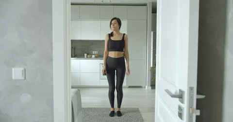 Young woman doing jumping exercise at home. Healthy lifestyle Stock Footage 129443001