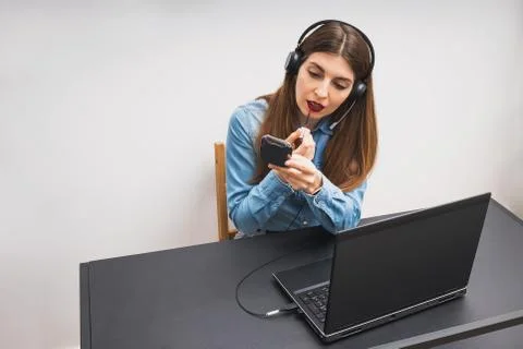 Young woman doing make up while sitting at the laptop. Stock Photos