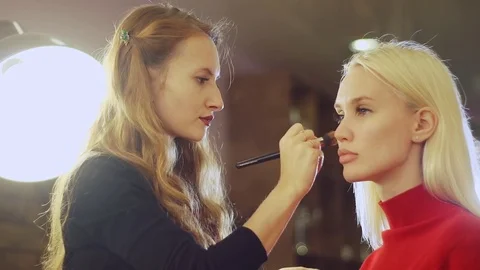 Young woman doing makeup on a model in a beauty salon. Stock Footage 71571131