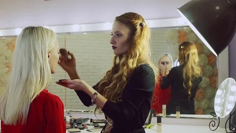 Young woman doing makeup on a model in a beauty salon. Stock Footage 71571233