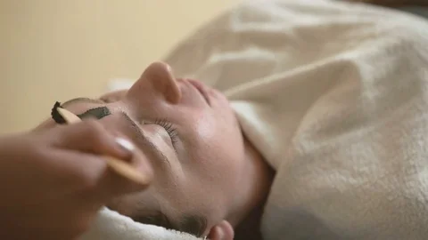 Young woman doing a mud face mask Stock Footage 69967580