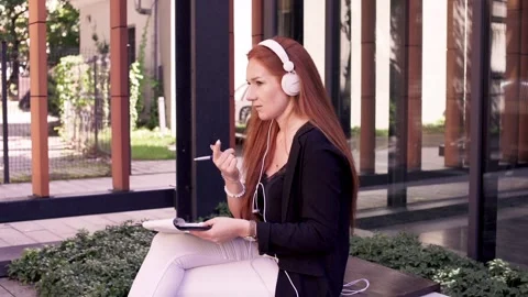 Young woman doing notes while sitting on the bench Stock Footage 86084466