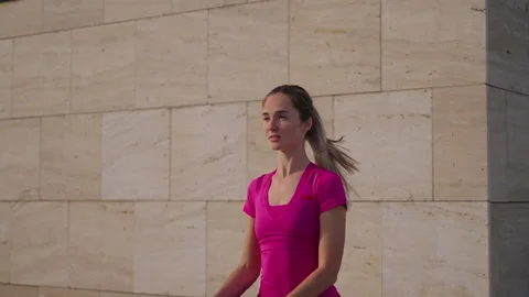 Young woman is doing physical exercise in city in morning, yoga practicing Stock Footage 168656211