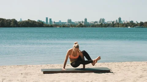 Young woman is doing professional yoga workout on the beach. Stock Footage 52367553