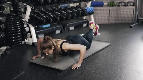 Young woman doing push ups in a gym 스톡 동영상 75653624