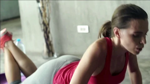 Young woman doing push-ups on mat in home Stock Footage 76950087