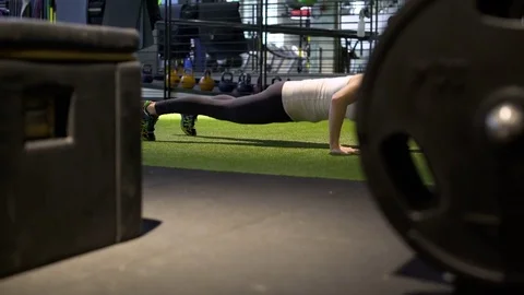 Young woman doing push-ups in a gym 動画素材 77091052