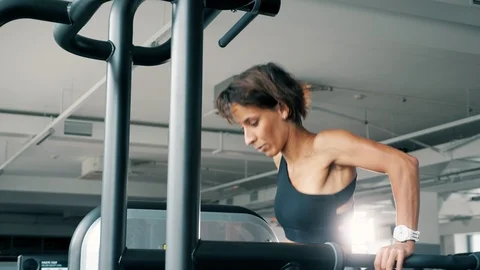 Young woman is doing push-ups on uneven bars in gym. Video stock 111136859