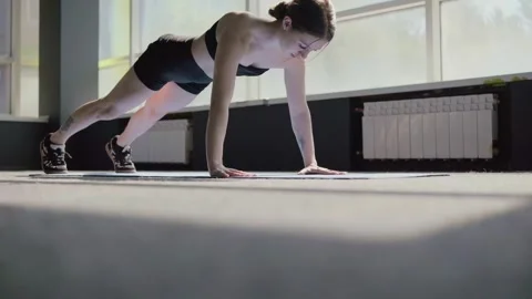 Young woman doing push-ups in a gym. Concept of sport and healthy lifestyle Stock Footage 308816357