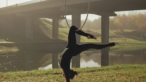 Young woman doing some acrobatic elements on aerial hoop outdoors in slow-mo Stock Footage 115083901
