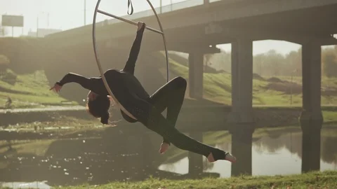 Young woman doing some acrobatic elements on aerial hoop outdoors in slow-mo Stock Footage 117425839