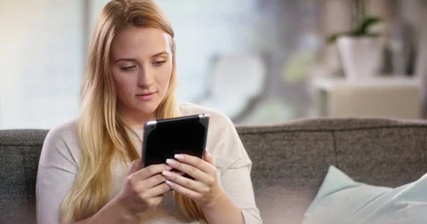 Young woman doing something on a tablet Stock Footage 78561991