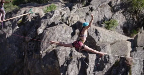 Young Woman doing a split on a Slacklines 스톡 동영상 73490939