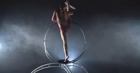Young woman is doing a standing split in a spinning hoop, gymnastics show, 4k Stock Footage 162887390