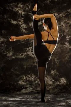Young woman doing a standing split yoga pose, shot from behind Stock Photos