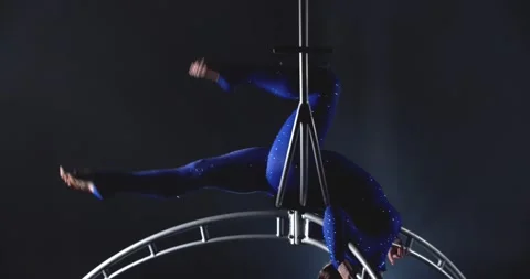 Young woman is doing an upside down split on a hoop, gymnastics, low lighting 4k Stock Footage 162886149
