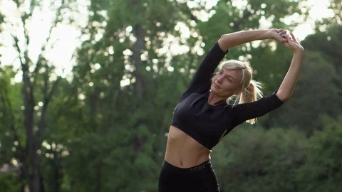 Young woman doing warm-up before exercise on nature Video stock 80220401