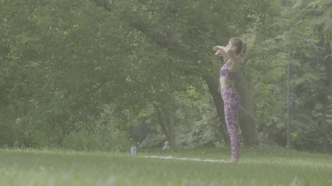 Young woman doing yoga exercises in the park Stock Footage
