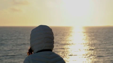 Young woman in down jacket taking photos of midnight sun 스톡 동영상 113211672