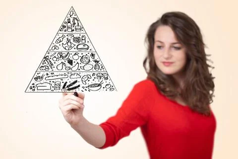 Young woman drawing a food pyramid on whiteboard Stock Photos