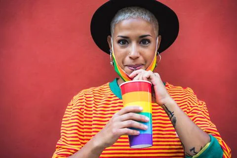 Young woman drinking cocktail during gay pride parade - LGBT community concept Stock Photos