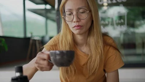 Young woman is drinking coffee in a cafe Stock Footage 198296691
