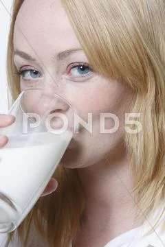 Young Woman Drinking Glass Of Milk, Portrait