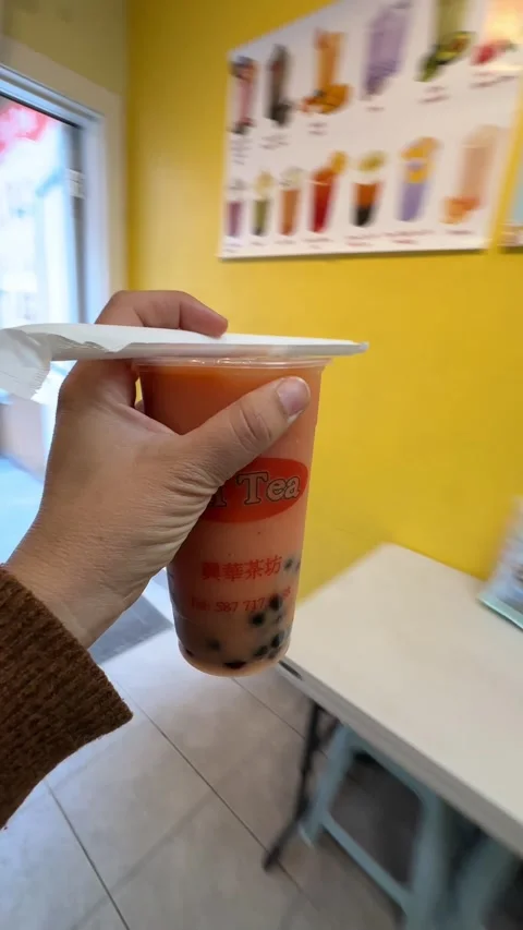 Young woman drinking a refreshing bubble tea on a sunny urban street in Stock Footage 333350461