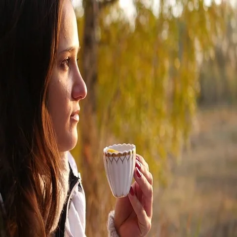 Young woman drinking tea while watching the sunset Stock Footage 69500360