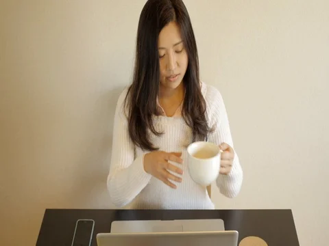 Young woman drinking tea while working. Stock Footage