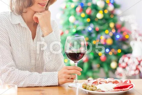 Young woman, drinking wine and having snack at home on christmas Stock Photos