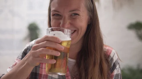 A young woman drinks beer in a cafe Stock Footage 110972797
