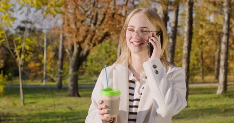Young woman drinks coffee talking on phone with friend Stock Footage 235322553