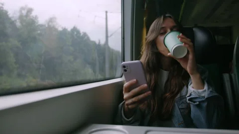 A young woman drinks coffee while traveling by train Stock Footage 218439564