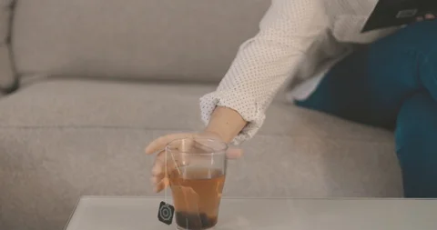 Young woman drinks you while reading a book on the sofa Video stock 101030617