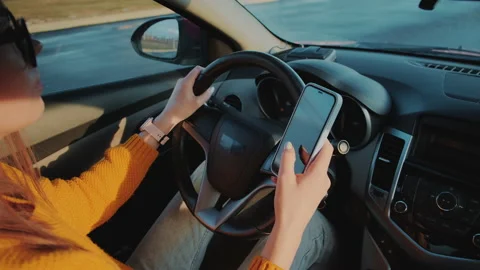 Young woman driver using mobile phone while driving car in motion, distracted Stock Footage 232232293
