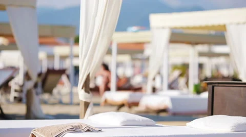 Young woman during tropical beach vacation. Fashion girl in white sunbeds at Stock Footage