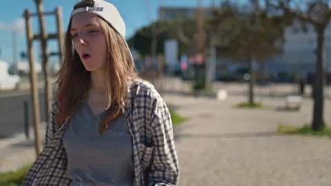 Young woman eating apple while walking on city street Stock Footage 310081079