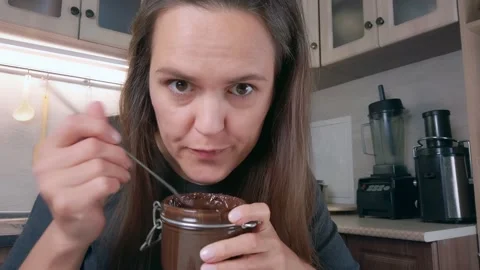 Young woman eating chocolate paste in th... | Stock Video | Pond5